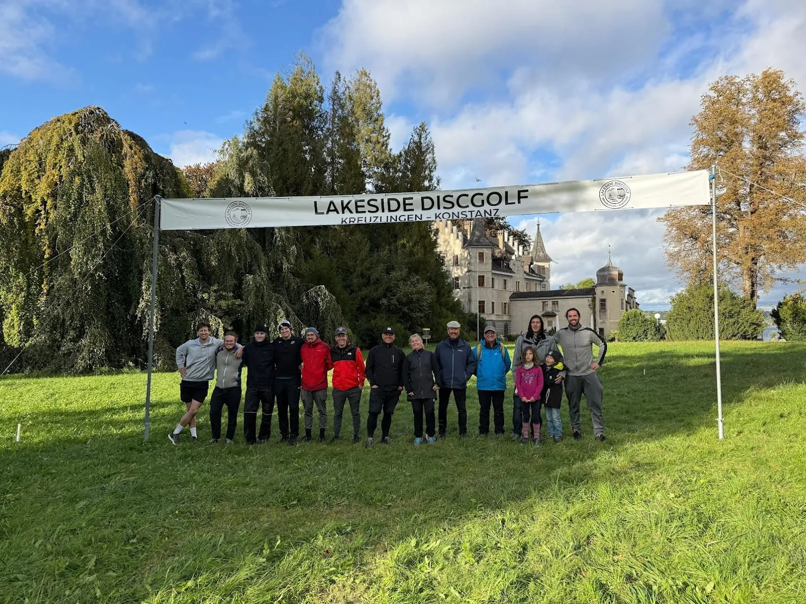 Gruppenfoto in türkisen Vereinsshirts zwischen zwei Lakeside-Discgolf-Fahnen