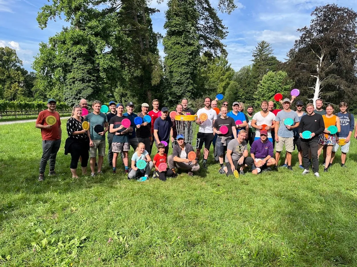 Gruppenfoto auf der Wiese, alle halten bunte Discs in den Händen