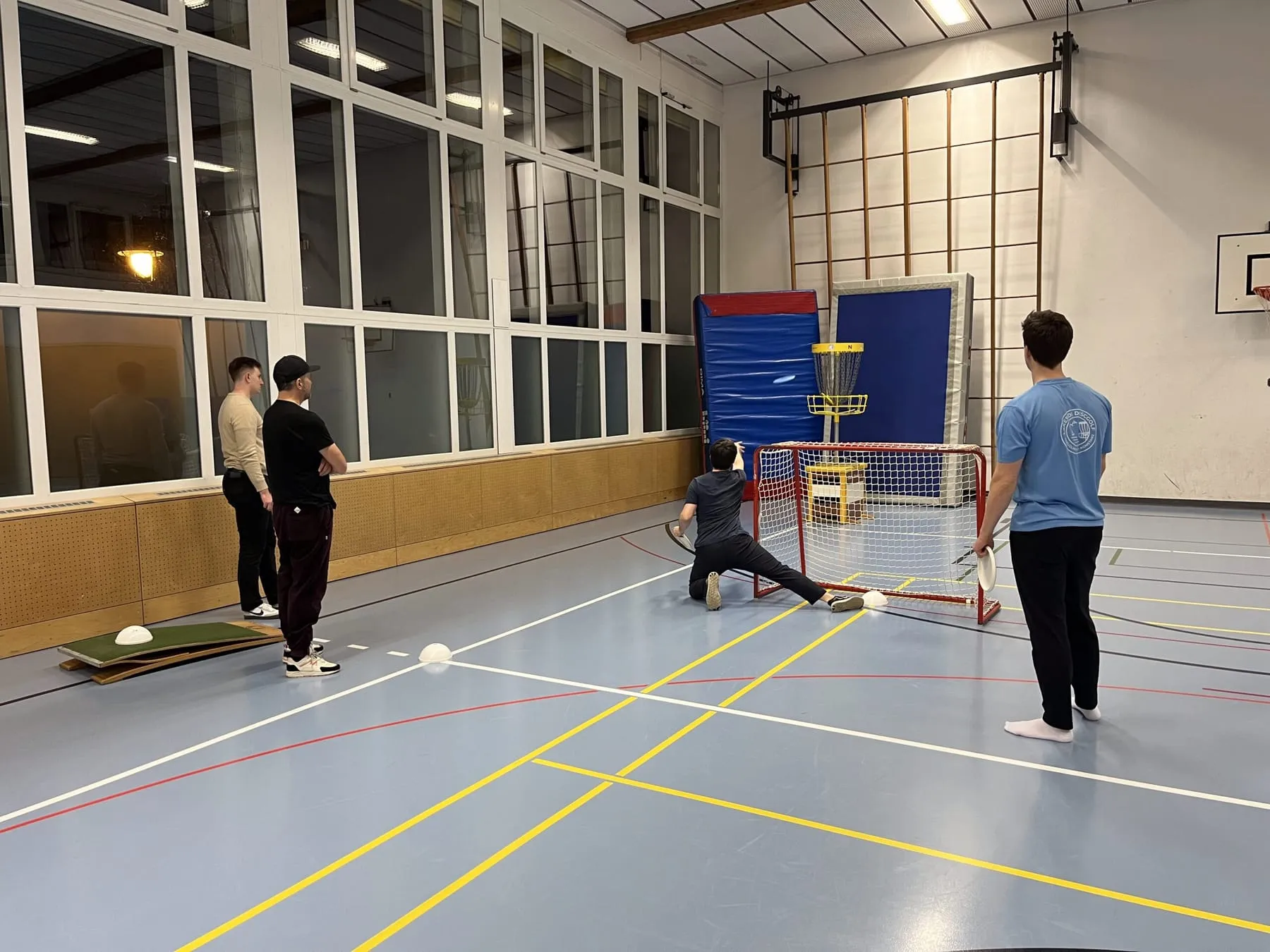 Gruppe schaut einem Putt in der Sporthalle zu